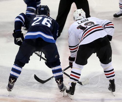 TREVOR HAGAN / WINNIPEG FREE PRESS Winnipeg Jets' Blake Wheeler (26) and Chicago Blackhawks' Andrew Ladd (16) line up for a face-off during third period NHL hockey action, Friday, March 18, 2016.