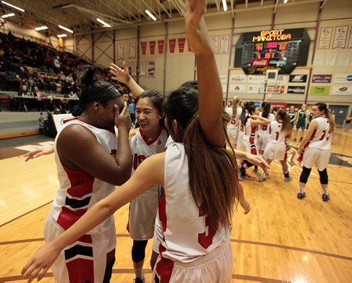 PHIL HOSSACK / WINNIPEG FREE PRESS Sisler Spartan #7 Kyanna Giles weeps as she's embraced by team mates #6 Raizel Guinto, #7 Kyia Giles and #3 Kiara Rongavilla  after the team won the MHSAA Basketball Championship Monday at Investor's Group Athletic Center.  MARCH 21, 2016