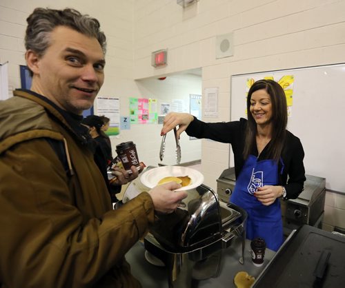 JASON HALSTEAD / WINNIPEG FREE PRESS  Carla Anjos-Clemente from the Corydon Village Royal Bank serves up breakfast at Ecole Robert H. Smith School's ninth annual community breakfast on March 4, 2016. This year, money raised by the River Heights school will go to the Children's Rehabilitation Foundation. (See Social Page)
