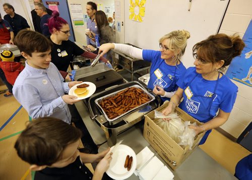 JASON HALSTEAD / WINNIPEG FREE PRESS  Michelle Floch (left) and Maria Alves Murphy from the Corydon Village Royal Bank serves breakfast at Ecole Robert H. Smith School's ninth annual community breakfast on March 4, 2016. This year, money raised by the River Heights school will go to the Children's Rehabilitation Foundation. (See Social Page)