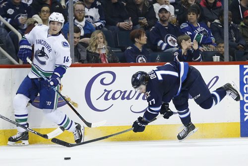 JOHN WOODS / WINNIPEG FREE PRESS Vancouver Canucks' Alexandre Burrows (14) checks Winnipeg Jets' Chase De Leo (77) during second period NHL action in Winnipeg on Tuesday, March 22, 2016.