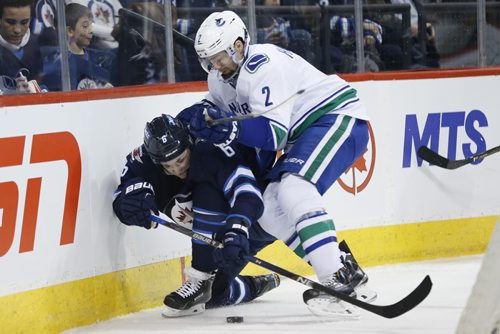 JOHN WOODS / WINNIPEG FREE PRESS Winnipeg Jets' Alex Burmistrov (6) ducks under Vancouver Canucks' Dan Hamhuis (2) to maintain control of the puck behind the Canuck net during second period NHL action in Winnipeg on Tuesday, March 22, 2016.