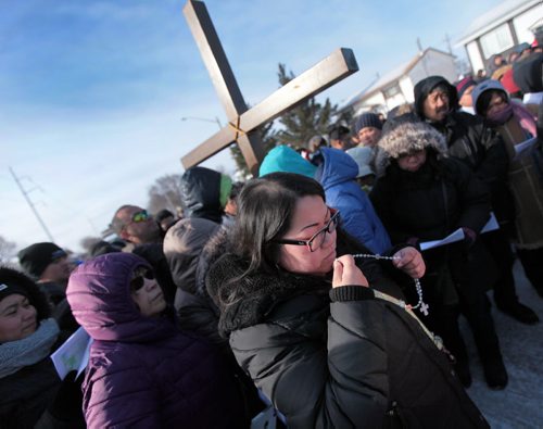 PHIL HOSSACK / WINNIPEG FREE PRESS A devout follower kisses her rosary in a procession of a thousand or more faithfull in a piblic procession from St Peter's Church on Keewatin street Friday morning to follow the "Stations of the Cross" as Easter weekend begins for Christians world wide. See Scott Billeck story. March 25, 2016