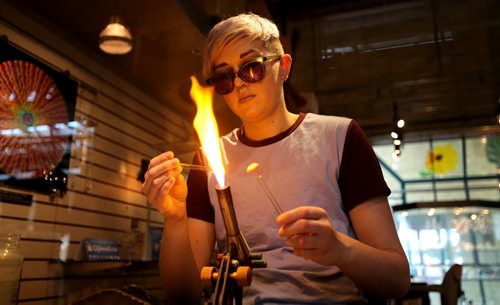 TREVOR HAGAN / WINNIPEG FREE PRESS Kirsten Loewen using a propane-oxygen torch to shape glass at Bayshore Gifts in Glass at The Forks, Saturday, March 26, 2016.