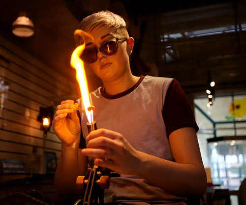 TREVOR HAGAN / WINNIPEG FREE PRESS Kirsten Loewen using a propane-oxygen torch to shape glass at Bayshore Gifts in Glass at The Forks, Saturday, March 26, 2016.