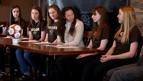 TREVOR HAGAN / WINNIPEG FREE PRESS Soccer players, Haydn Burdeny, Sarah Lyle, Camille Forbes, head coach Vanessa Martinez Lagunas, Shaylyn Dyck and Rebecca Martin, sign their intent to join the University of Manitoba Bisons team, during a press conference at Smitty's on Pembina, Monday, March 28, 2016.