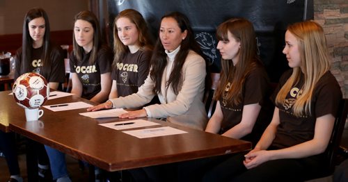 TREVOR HAGAN / WINNIPEG FREE PRESS Soccer players, Haydn Burdeny, Sarah Lyle, Camille Forbes, head coach Vanessa Martinez Lagunas, Shaylyn Dyck and Rebecca Martin, sign their intent to join the University of Manitoba Bisons team, during a press conference at Smitty's on Pembina, Monday, March 28, 2016.