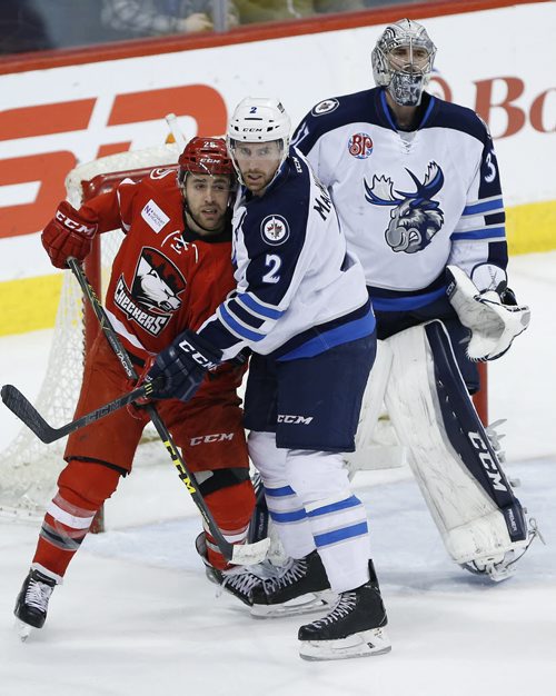 JOHN WOODS / WINNIPEG FREE PRESS Manitoba Moose Andrew MacWilliam (2) jostles with Charlotte Checkers' Ethan Werek (25) in front of Moose goaltender Conor Hellebuyck (37) during first period AHL action in Winnipeg on Monday, March 28, 2016.