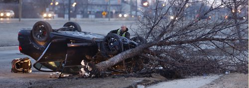 WAYNE GLOWACKI / WINNIPEG FREE PRESS  A tow truck operator prepares to remove an overturned car on Gateway Rd. just north of Burnett Ave.¤Tuesday morning.¤ There was only one person in the vehicle at the time of the crash and is listed in stable condition.  March 29 2016
