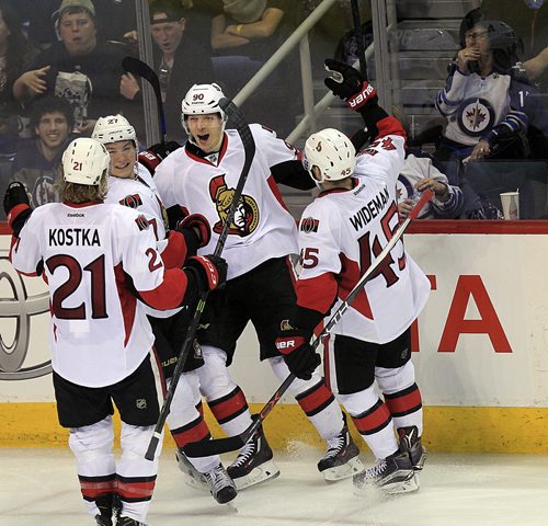 PHIL HOSSACK / WINNIPEG FREE PRESS Left to Right Ottawa Senators #21 Michael Kostka, #27 Curtis Lazar, #90 Alex Chaisson and #45 Chris Wideman celbrate Chaisson's game winning goal in the third period at the MTS Center Wedneday.  MARCH 30, 2016