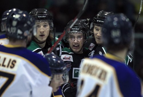 PHIL HOSSACK / WINNIPEG FREE PRESS Twin Portage Terriers Shawn (#15) left, and (#9) Brad Bowles flank Nick Henry (#27) left, to stare down the Blues after the pair teamed up to assist Henry score the second unanswered goal Against Winnipeg's Blues in semi-final action at the Ice Plex Friday. April 1, 2016