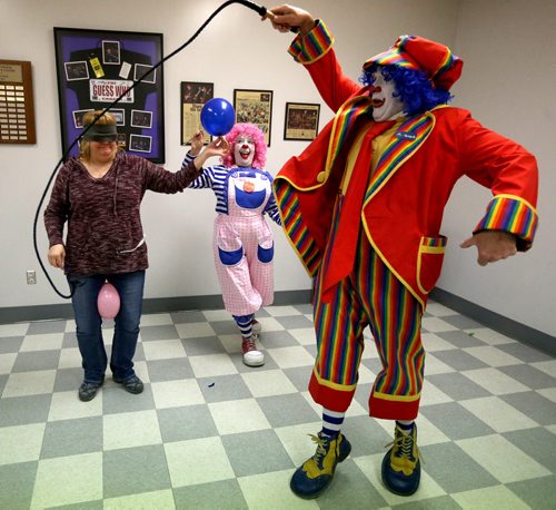 TREVOR HAGAN / WINNIPEG FREE PRESS Puff the clown, middle, pops a balloon held by Tannis Fillion as Mr.Squiggly cracks a whip during a rehearsal at Crescentwood Community Centre, Thursday, March 31, 2016. They are all members of the World Clown Association, and are having a show on April 23rd. 49.8 article for Dave Sanderson.