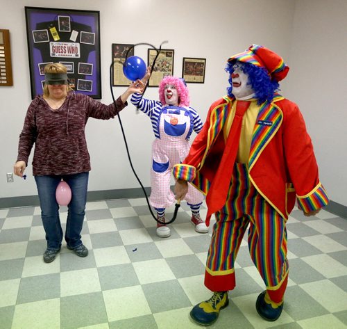 TREVOR HAGAN / WINNIPEG FREE PRESS Puff the clown, middle, pops a balloon held by Tannis Fillion as Mr.Squiggly cracks a whip during a rehearsal at Crescentwood Community Centre, Thursday, March 31, 2016. They are all members of the World Clown Association, and are having a show on April 23rd. 49.8 article for Dave Sanderson.