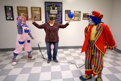 TREVOR HAGAN / WINNIPEG FREE PRESS Puff the clown pops a balloon held by Tannis Fillion as Mr.Squiggly cracks a whip during a rehearsal at Crescentwood Community Centre, Thursday, March 31, 2016. They are all members of the World Clown Association, and are having a show on April 23rd. 49.8 article for Dave Sanderson.