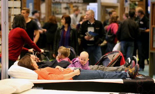 TREVOR HAGAN / WINNIPEG FREE PRESS Mandy Blue, Anthony Cherewyk and Sydney Cherewyk, 14 mo, in the Sleep Country display at the Winnipeg Home and Garden Show at the Winnipeg Convention Centre, Saturday, April 2, 2016.