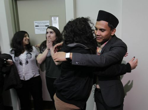 RUTH BONNEVILLE / WINNIPEG FREE PRESS  Malaysian student Hazim Ismail (right) gets a hug from good friend Alexa Potashnik outside the refugee hearing office in Winnipeg Tuesday morning after winning his case against being deported back to Malaysia where he had been given death threats due to his sexual orientation.   See Carol Sanders story.      April 05, 2016