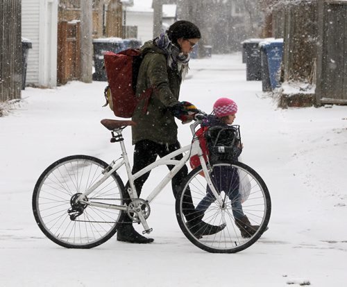 BORIS MINKEVICH / WINNIPEG FREE PRESS Weather photo - Courtney Gilchrist pushes her bike with her daughter Ivy, 4, down Wolseley Ave. Ivy is in Kindergarten and school just finished. April 5, 2016