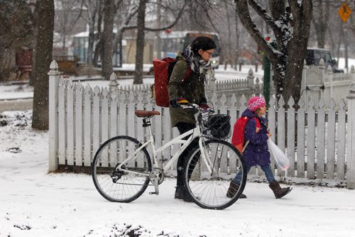 BORIS MINKEVICH / WINNIPEG FREE PRESS Weather photo - Courtney Gilchrist pushes her bike with her daughter Ivy, 4, down Wolseley Ave. Ivy is in Kindergarten and school just finished. April 5, 2016