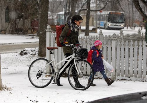 BORIS MINKEVICH / WINNIPEG FREE PRESS Weather photo - Courtney Gilchrist pushes her bike with her daughter Ivy, 4, down Wolseley Ave. Ivy is in Kindergarten and school just finished. April 5, 2016