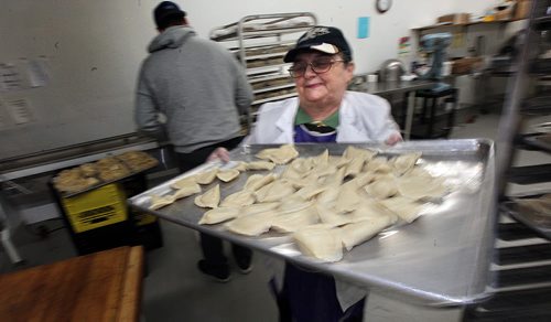 PHIL HOSSACK / WINNIPEG FREE PRESS Perogy Planet's Lydia Rabada sweeps a tray of finished perogy off for packaging.  Dave Sanderson story. - April 5, 2016