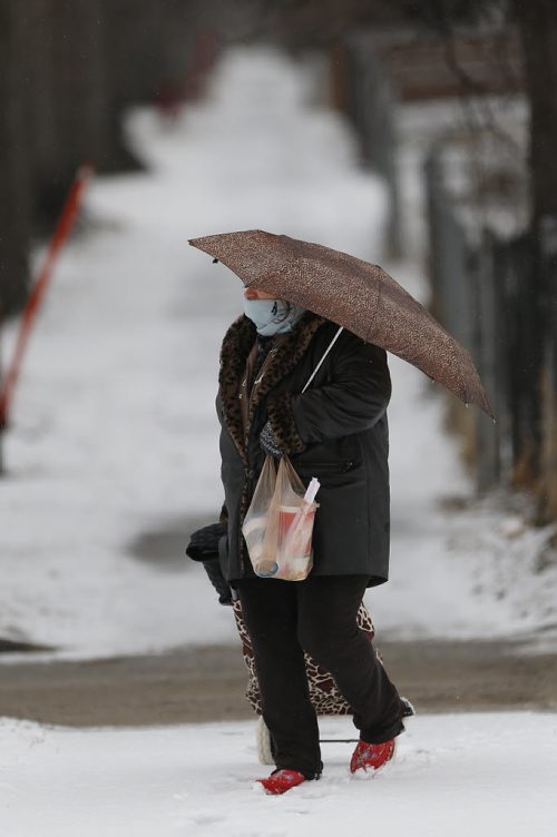 JOHN WOODS / WINNIPEG FREE PRESS A woman makes her way through a light snowfall in north Winnipeg Tuesday, April 5, 2016.