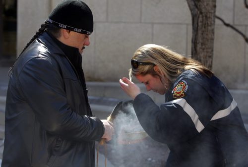 BORIS MINKEVICH / WINNIPEG FREE PRESS Smudging Ceremony led by the Bear Clan Patrol to celebrate 2016 National Public Safety Telecommunicators Week. His Worship, Mayor Brian Bowman and Chief John Lane, Winnipeg Fire Paramedic Service was there. The Break Clan smudges an unidentified WFPS member. Event held at City Hall courtyard  510 Main Street. April 11, 2016 -30-