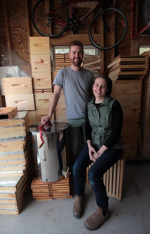 PHIL HOSSACK / WINNIPEG FREE PRESS Chris and Lindsay Kirouac pose with Supers, (beehive boxes) stored in their Windsor Park home's garage. See Dave Sanderson's story.  APRIL 12, 2016
