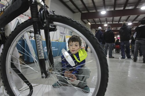 RUTH BONNEVILLE  Ten-year-old Hunter Wiebe, checks out his new/used bike  that his mom bought for him at the City of Winnipeg annual unclaimed bike auction at East End Arena Saturday.Standup photo  April 16, 2016