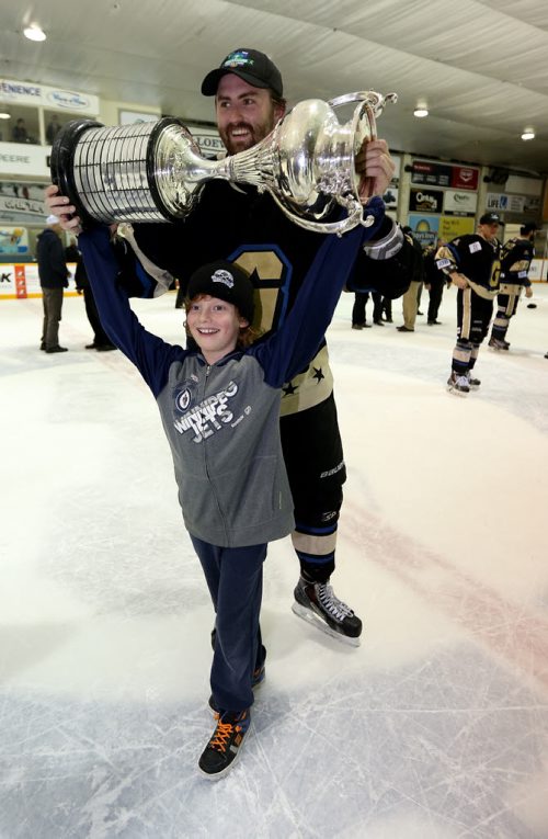 TREVOR HAGAN / WINNIPEG FREE PRESSBentley Generals Jesse Todd shares the trophy with his cousin, Riley Brown, 8, as they celebrate winning the 2016 Allan Cup in Steinbach after defeating the Southeast Prairie Thunder in overtime, Saturday, April 16, 2016.