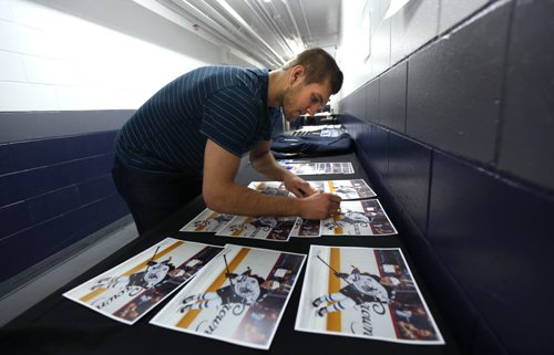WAYNE GLOWACKI / WINNIPEG FREE PRESS    Manitoba Moose defenceman Brenden Kichton, the top scorer for the team this season signs photographs outside the Moose dressing room at the MTS Icleplex. With the season now over, players were cleaning out their lockers and meeting with coaches Monday. Tim Campbell story.  April 18  2016