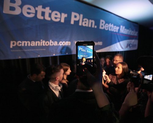 PHIL HOSSACK / WINNIPEG FREE PRESS Premier elect now, Brian Pallister is framed in a fan's iPhone post PC "party" Tuesday night.  See story. April 19, 2016