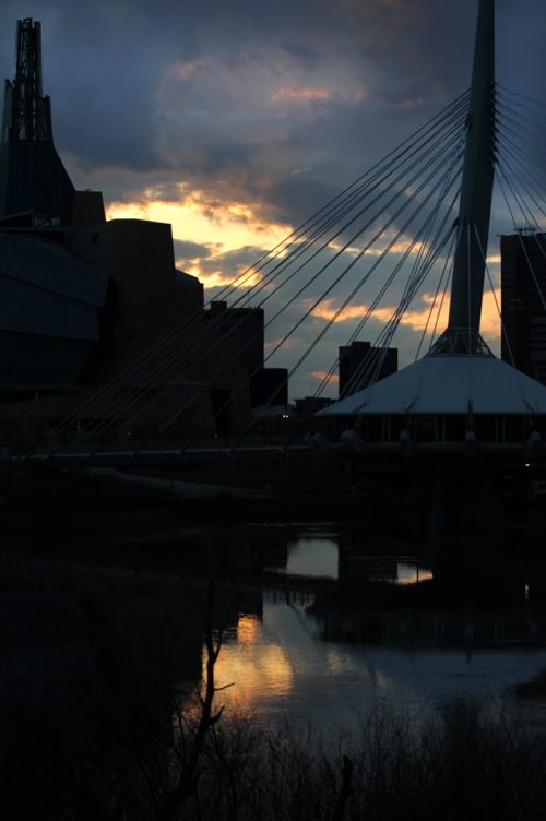 RUTH BONNEVILLE / WINNIPEG FREE PRESS
 The CMHR building is silhouetted  against a spectacular view of the sun shining through the clouds reflected on the Red River from Tache Promenade Wednesday evening.   Standup photo  APRIL 20, 2016