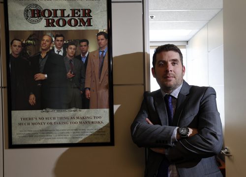 WAYNE GLOWACKI / WINNIPEG FREE PRESS        Jason Roy, a Manitoba Securities Commission senior investigator beside the poster for Boiler Room, a movie about investment fraud hanging outside his office.  He received a random call at home last week from one of these offshore investment scammers trying to get him to invest in binary options. He  played along and milked the guy (hes from Israel) for all the information he could. Now hes trying to get him charged. Murray McNeill  story April 21  2016