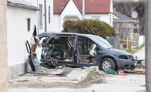 MIKE DEAL / WINNIPEG FREE PRESS  A van sits in a yard after colliding with a hydro poll and clipping the detached garage of a house on Arlington Street early Sunday morning. No word on injuries.   160424 Sunday, April 24, 2016