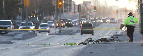 WAYNE GLOWACKI / WINNIPEG FREE PRESS   A Winnipeg Police officer collects evidence on Nairn Ave. near Chester St. Tuesday morning after a cyclist was struck by a vehicle over night.There were two bicycles at the scene, one at right on the sidewalk and a mangled bike on Nairn Ave.  Bill Redekop story  April 26 2016