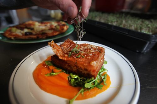 JOE BRYKSA / WINNIPEG FREE PRESS  Head chef Mike Day uses fresh garnish for a pork belly dish at the Black Rabbit in the Village  .(See 49.8 story)