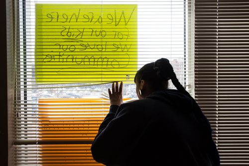 MIKE DEAL / WINNIPEG FREE PRESS Lisa Strong an Anishinabe Ikwe Ojibway woman looks outside a window covered in posters in the INAC office on Hargrave Street Monday afternoon. For nearly two weeks, groups of indigenous protesters have occupied INAC offices in Winnipeg, Toronto and Vancouver. Similar protests have been staged in Regina and Gatineau, Que. 160426 - Tuesday, April 26, 2016