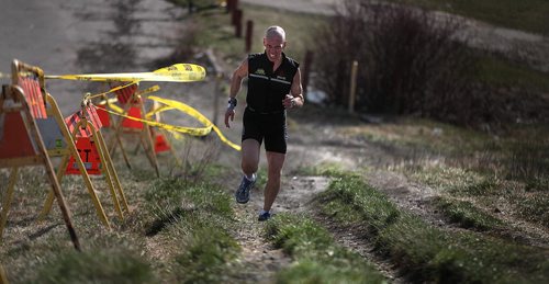 PHIL HOSSACK / WINNIPEG FREE PRESS Grimacing all the way, Vic Keller trains running up the steep part of Westview Park's "Garbage Hill"  Tuesday evening. The city is going to repair erosion from cyclists and runners sprinting up the grassy slope. Geoff Kirbyson's story April 26, 2016