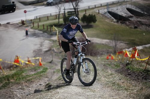 PHIL HOSSACK / WINNIPEG FREE PRESS Jim Edmond cranks his way up the steep part of Westview Park's "Garbage Hill"  Tuesday evening. The city is going to repair erosion from cyclists and runners sprinting up the grassy slope. Geoff Kirbyson's story April 26, 2016