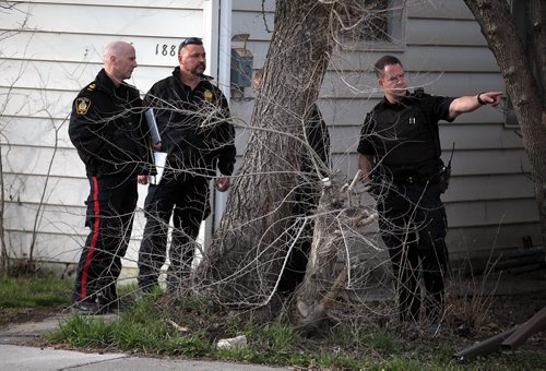 PHIL HOSSACK / WINNIPEG FREE PRESS Forensics officers confer in front of 1887 Alexander ave  (littered with medical supply refuse from responders) where a man was stabbed Wednesday afternoon. See Alex Paul's story. April 27, 2016