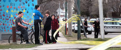 PHIL HOSSACK / WINNIPEG FREE PRESS Kids and a cadet watch outside the police tape as city offiers investigate a scene where a man was stabbed Wednesday afternoon in the 1800 block of Alexander ave. See Alex Paul's story. April 27, 2016