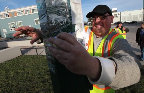 PHIL HOSSACK / WINNIPEG FREE PRESS BEAR CLAN - Dan Gordon warps tape around a missing persons poster while walking with the Bear Clan Patrol. See Alex Paul's story.  April 28, 2016
