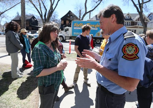 JASON HALSTEAD / WINNIPEG FREE PRESS  Neda Procner, who was pulled out of a fire in her Maryland Street home on April 23 with sister Helen Procner, speaks to Winnipeg Fire Department Lt. Rob Campbell at a barbecue held for the two at Westminster United Church in Wolseley on April 30, 2016. Campbell worked at the scene of the blaze.