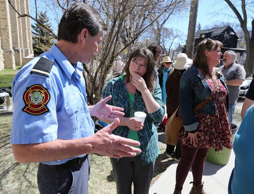 JASON HALSTEAD / WINNIPEG FREE PRESS  Neda Procner, who was pulled out of a fire in her Maryland Street home on April 23 with sister Helen Procner, speaks to Winnipeg Fire Department Lt. Rob Campbell at a barbecue held for the two at Westminster United Church in Wolseley on April 30, 2016. Campbell worked at the scene of the blaze.