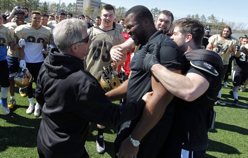 BORIS MINKEVICH / WINNIPEG FREE PRESS Bison football defensive lineman David Onyemata  is hugged by coach Brian Dobie . After his selection in the NFL Draft he was celebrated by all the Bison Football players after practice today at the University of Manitoba turf field. April 30, 2016