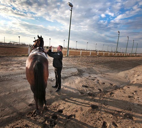 PHIL HOSSACK / WINNIPEG FREE PRESS Assistant Director of Racing Derek Corbel stops to help remopunt an Exercise rider and repair a loose stirrup while walking the grounds Monday morning.  The track's Opening Day first day's Post Time is Sunday at 730 pm. May 2, 2016