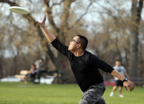 JASON HALSTEAD / WINNIPEG FREE PRESS  James Gomez chases the Frisbee thrown by his friend Deril Carranza as they enjoyed the warm evening on May 2, 2016, at Assiniboine Park. (For standup photo)