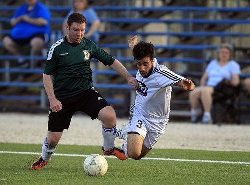 PHIL HOSSACK / WINNIPEG FREE PRESS Britannia Rover #3 Ali Elmoudi goes fown over the toe (after a trip) of Kildonan Cavalier #24 Kyle Geisbrecht Thursday evening at the soccer complex. See story? May 5, 2016