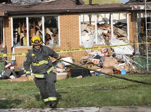 JOE BRYKSA / WINNIPEG FREE PRESS Fire crews cleanup outside a home in the 300 Block of Hudson St Friday morning. The fire started at aprx 1 AM this morning and spread quickly through the duplex. The home was jam packed full of items that cover the homes front lawn, May 06 , 2016.(Breaking News)