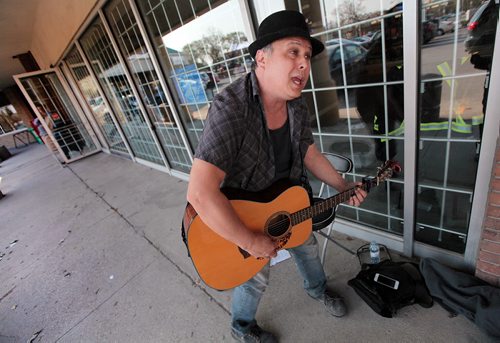 PHIL HOSSACK / WINNIPEG FREE PRESS - Tim (last name refused) dances to his own tune as he busks out front of the Manitoba Liquor store at Marion and St Mary's Road Friday afternoon. Tim Busks 3 times a week after working his day job and doesn't beleive buskers need lisencing. See story. May 6, 2016